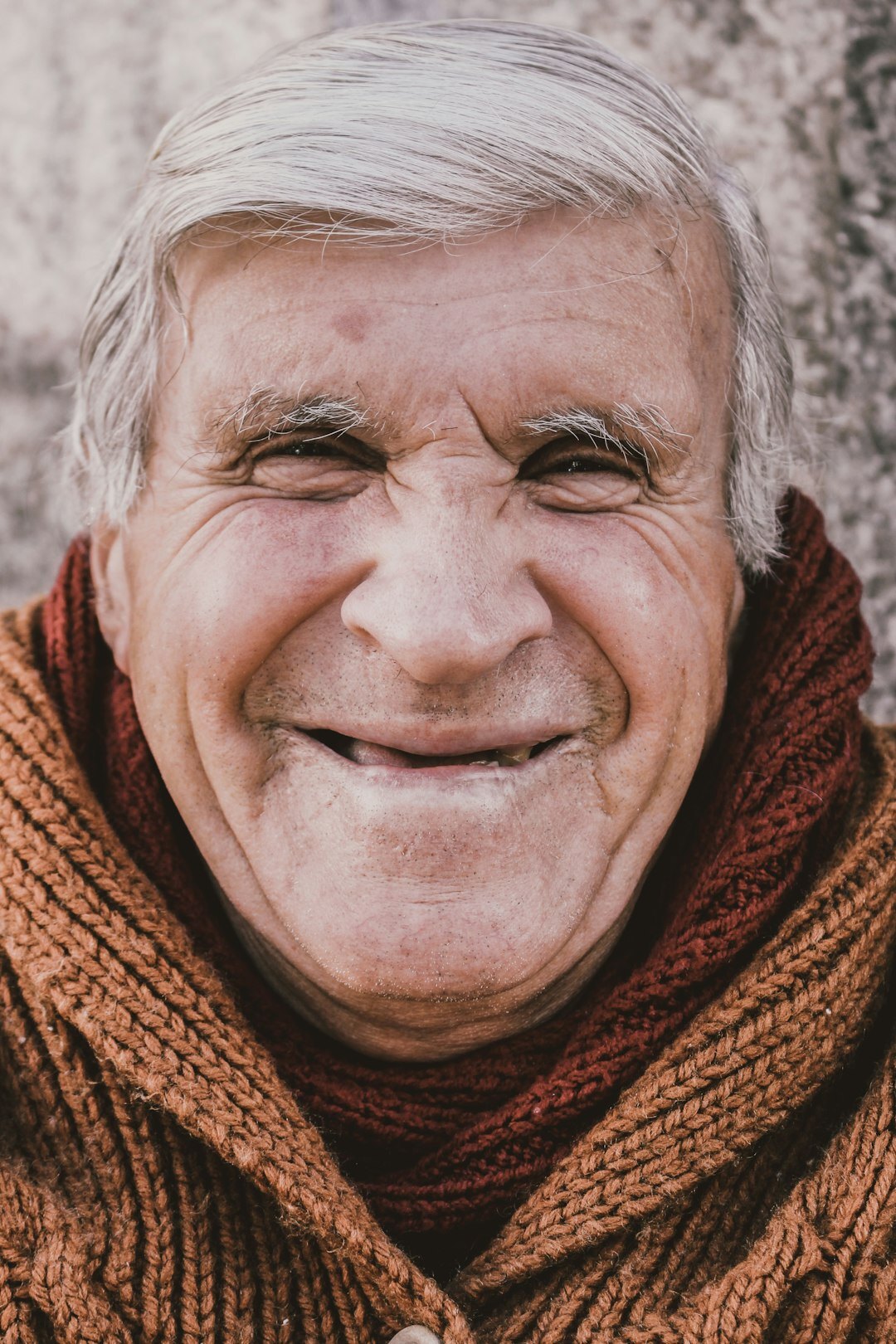 Studio portrait of a smiling Slovak senior man in a wool sweater